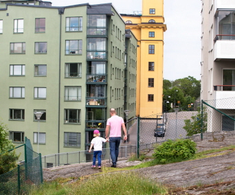Pappa och barn går utanför ett hyreshus. Foto: Hans Ekestang