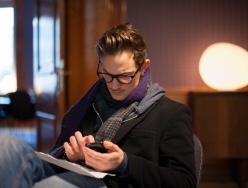 En man tittar på sin mobiltelefon