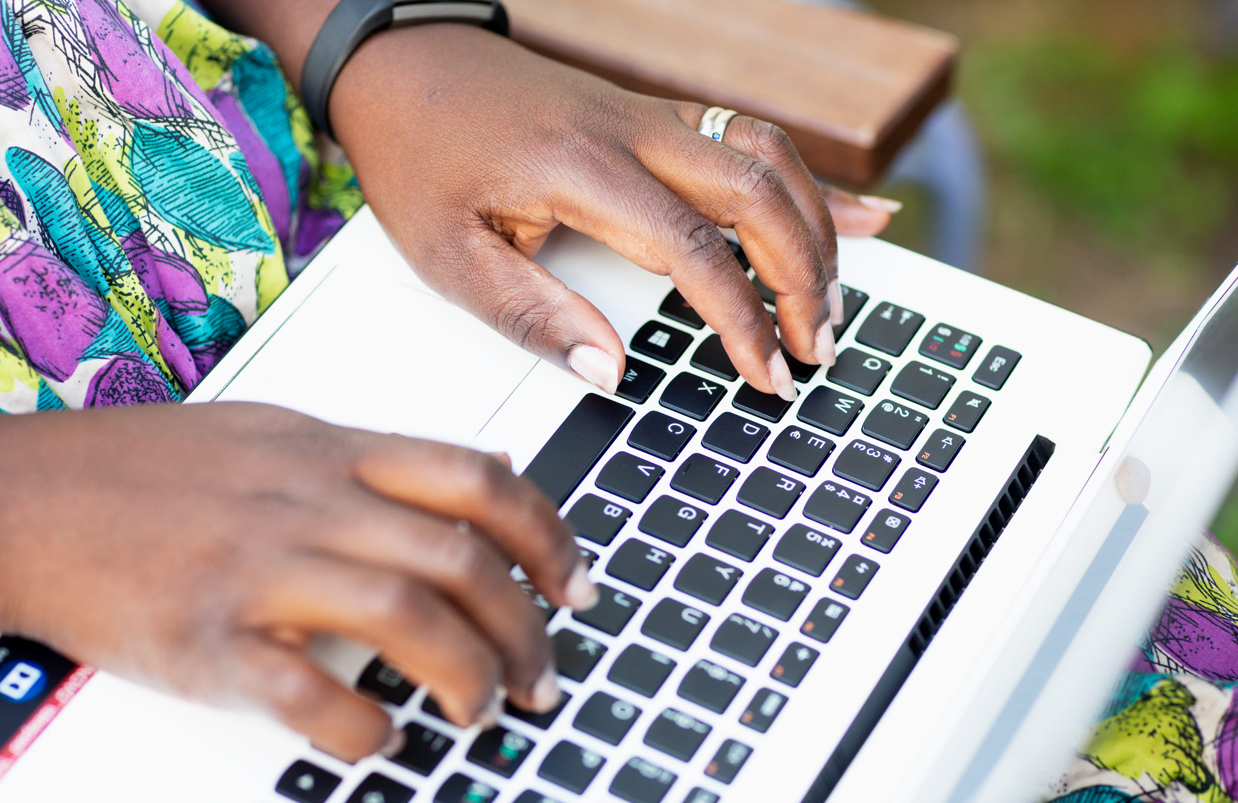 Närbild på kvinnas händer som skriver på laptop.