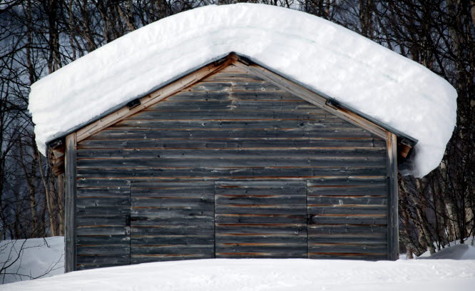 Foto på snötäckt träbyggnad.