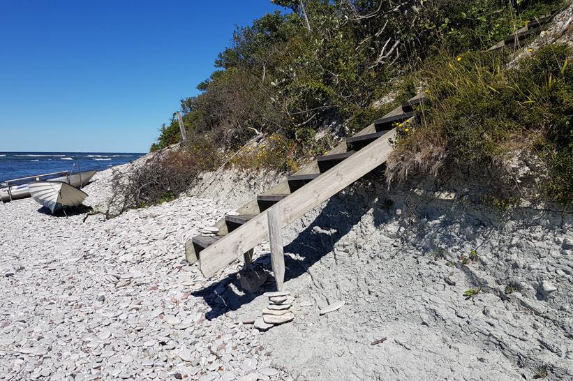 En trappa som leder ner till stranden  saknar kontakt med marken till följd av erosion. Foto:n.