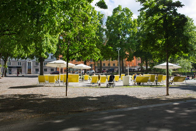 Torgbildning i parkmiljö med vilstolar.