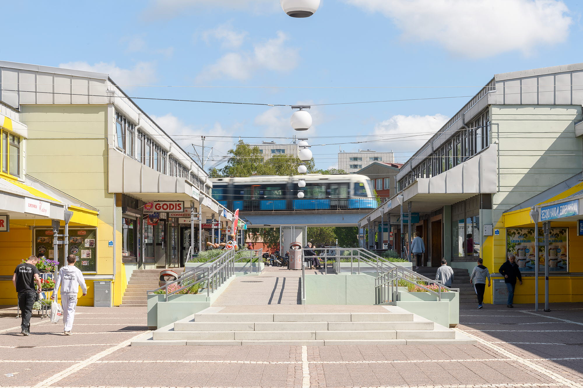 Bilden visar Vårväderstorget. I torgbilden syns människor i rörelse samt en spårvagn.