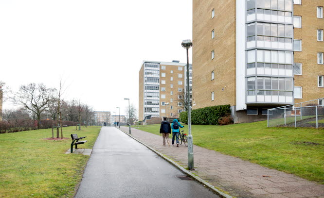 Människor promenerar på trottoar utanför flerbostadshus. Foto: Peter Kroon