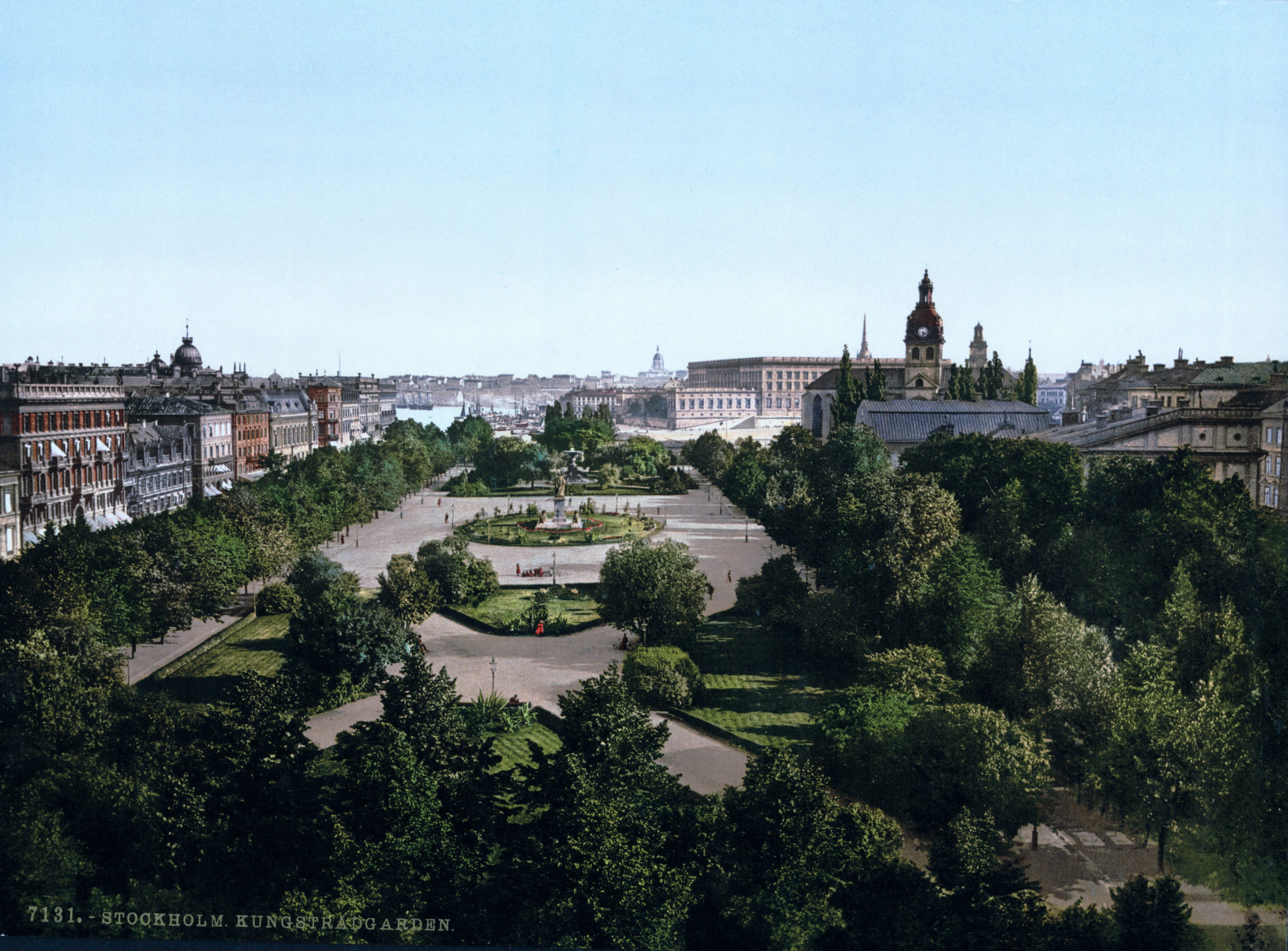 Park med träd, gräsmattor och grus.