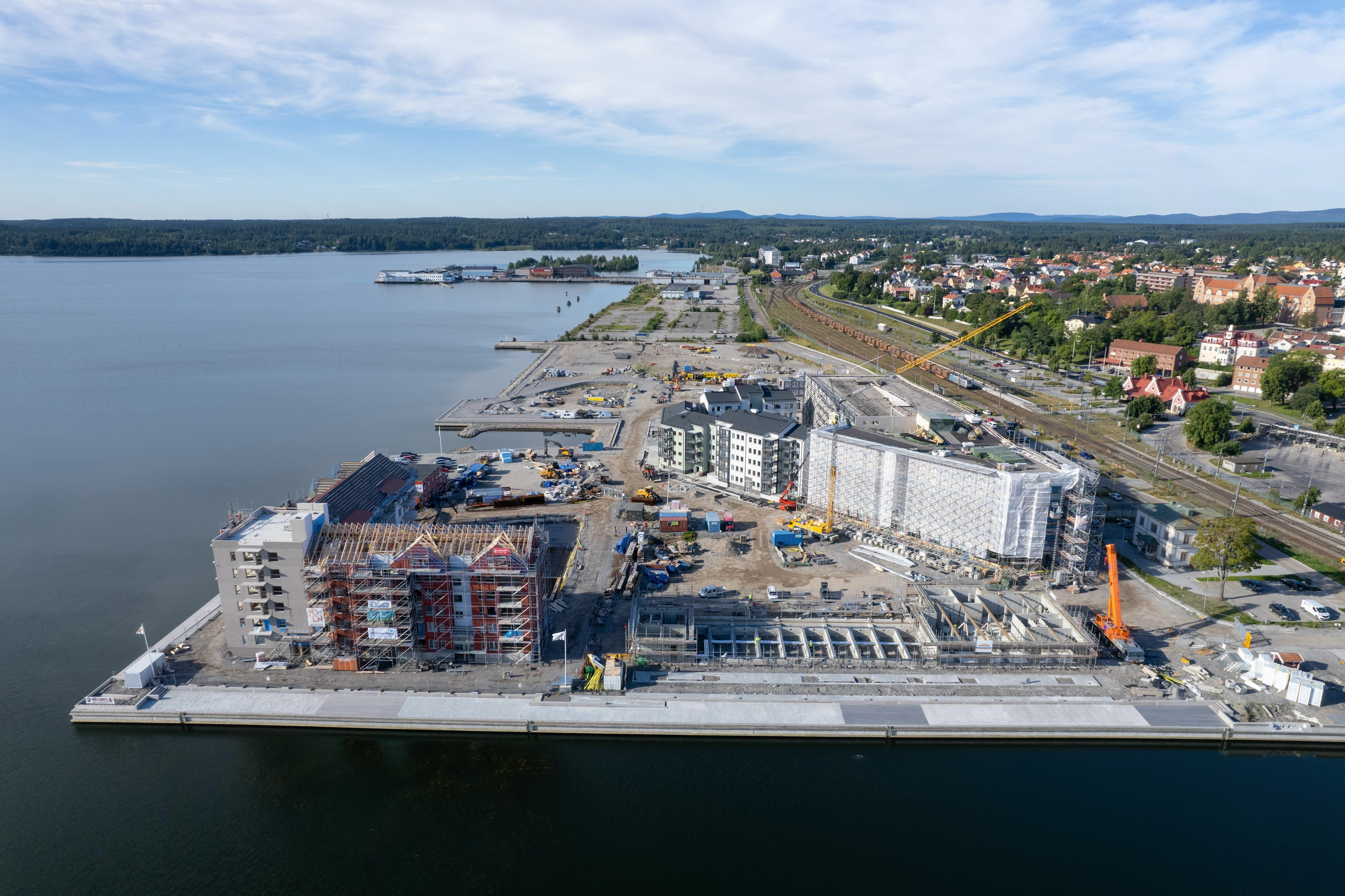 Flygfoto över byggnader och byggarbetsplats längs en kaj.