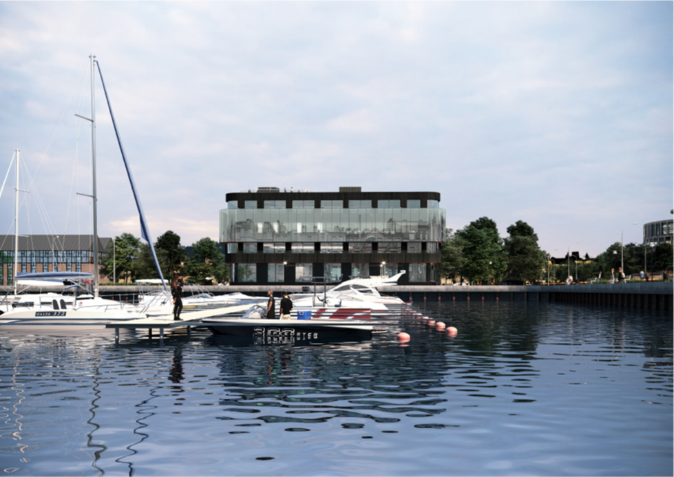 Kontorsbyggnad vid en kajkant med segelbåtar på en brygga framför.