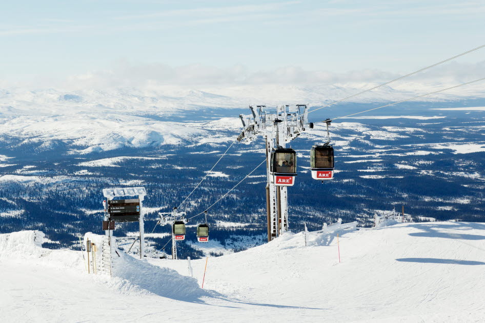 Foto på gondolbana över en snöig backe.