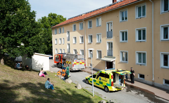 Brandbil och ambulans utanför ett bostadshus.