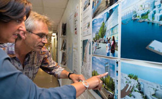 Två personer pekar på arkitektskisser. Foto: Franz Feldmanis 