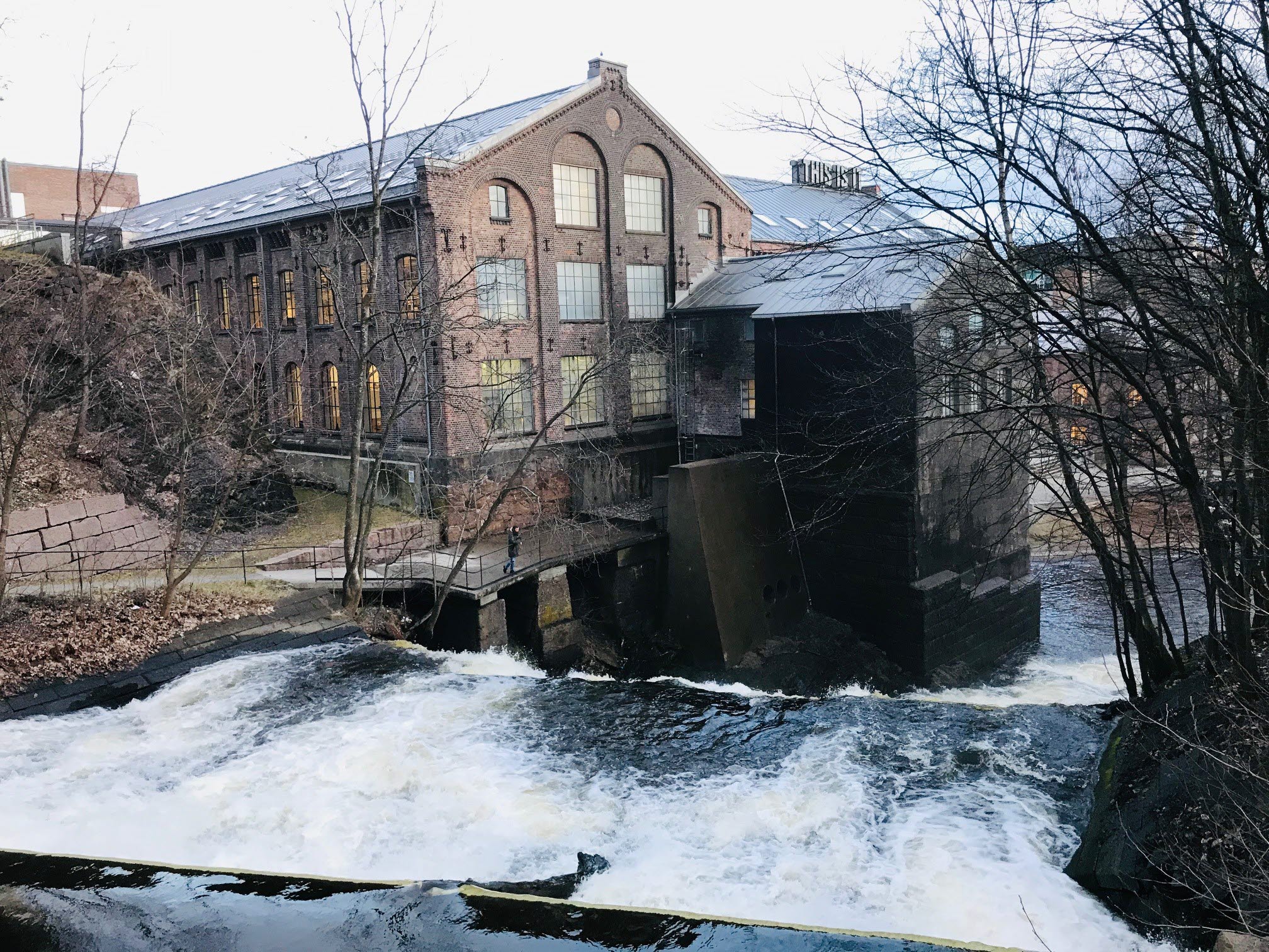 Ett tegelhus som står bakom ett vattenfall.