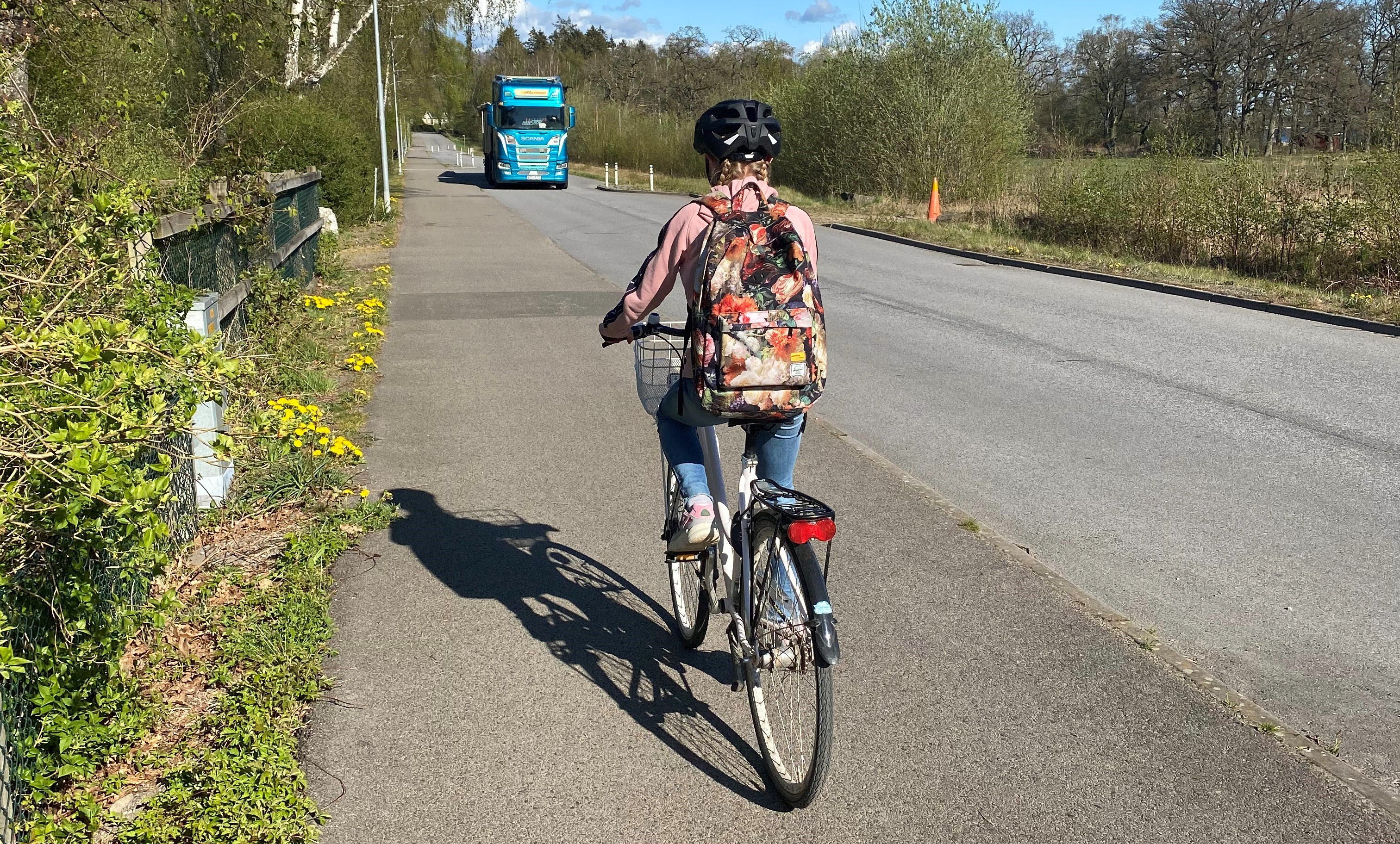 Barn som cyklar längs landsväg.