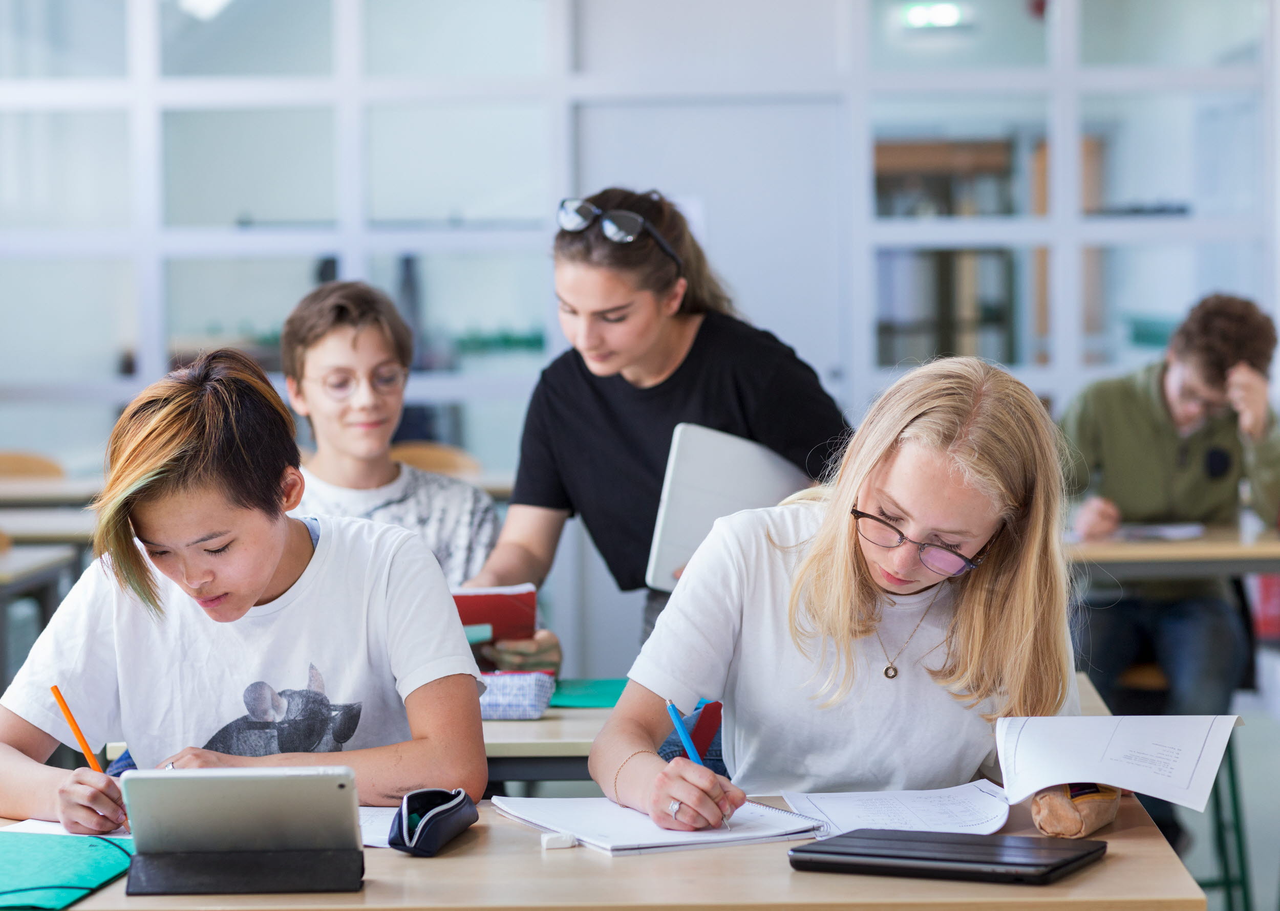 Foto på lärare och elever i klassrum.