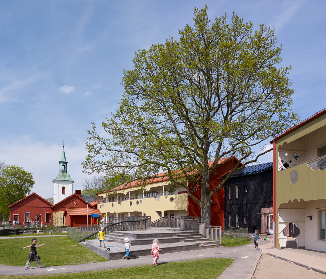 Barn som går på olika gångvägar framför skolans byggnader.