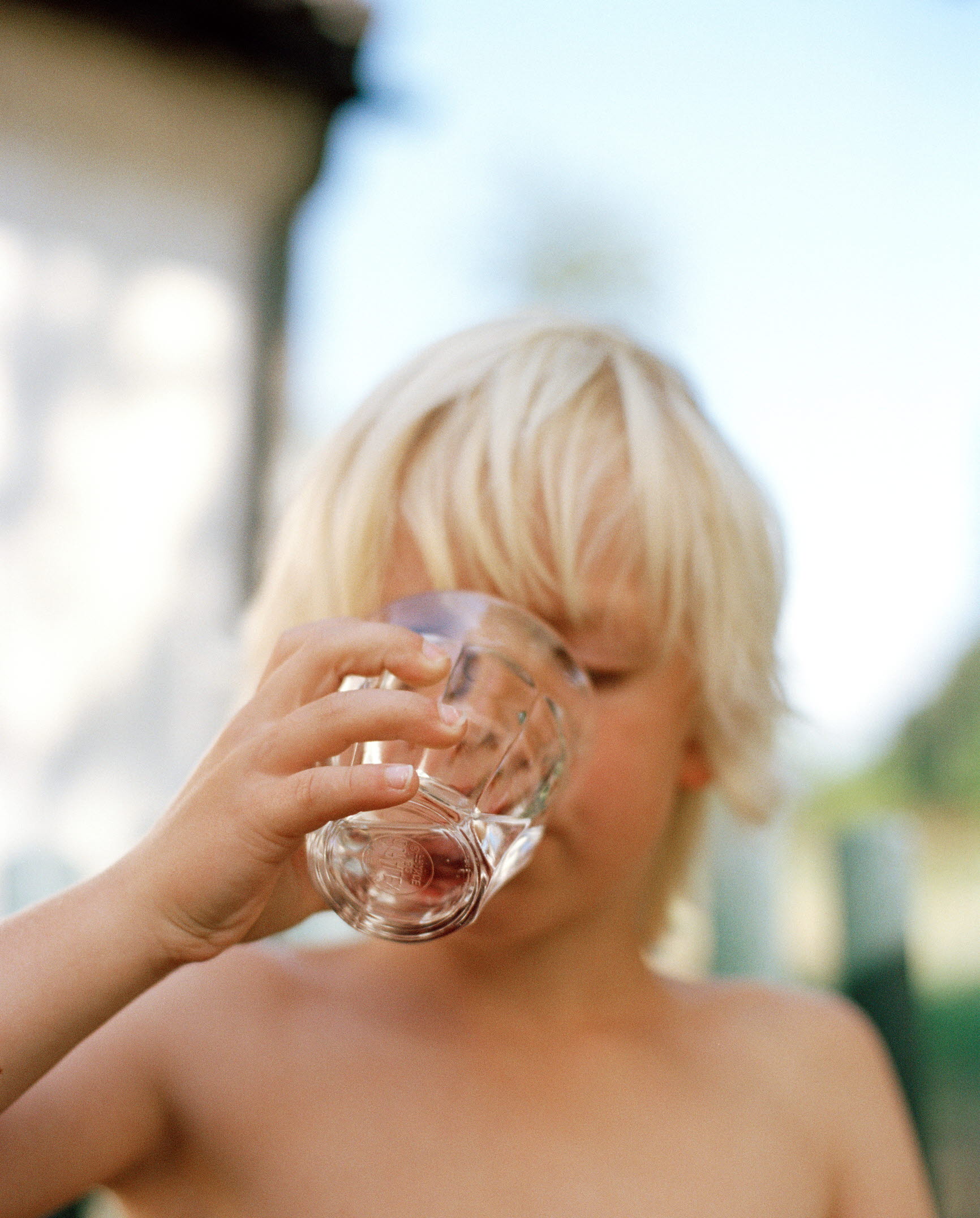 Ett barn som dricker vatten ur ett glas.