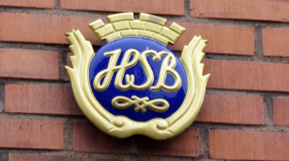 Foto av skylt med HSB:s logotype på en tegelfasad.