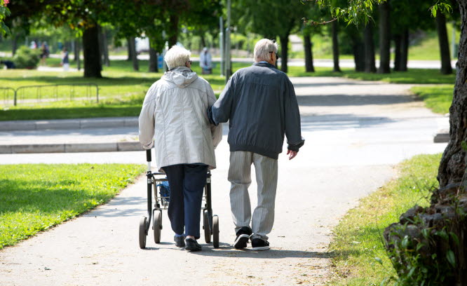 Två äldre människor promenerar tillsammans i en park. Foto: Hans Ekestang.