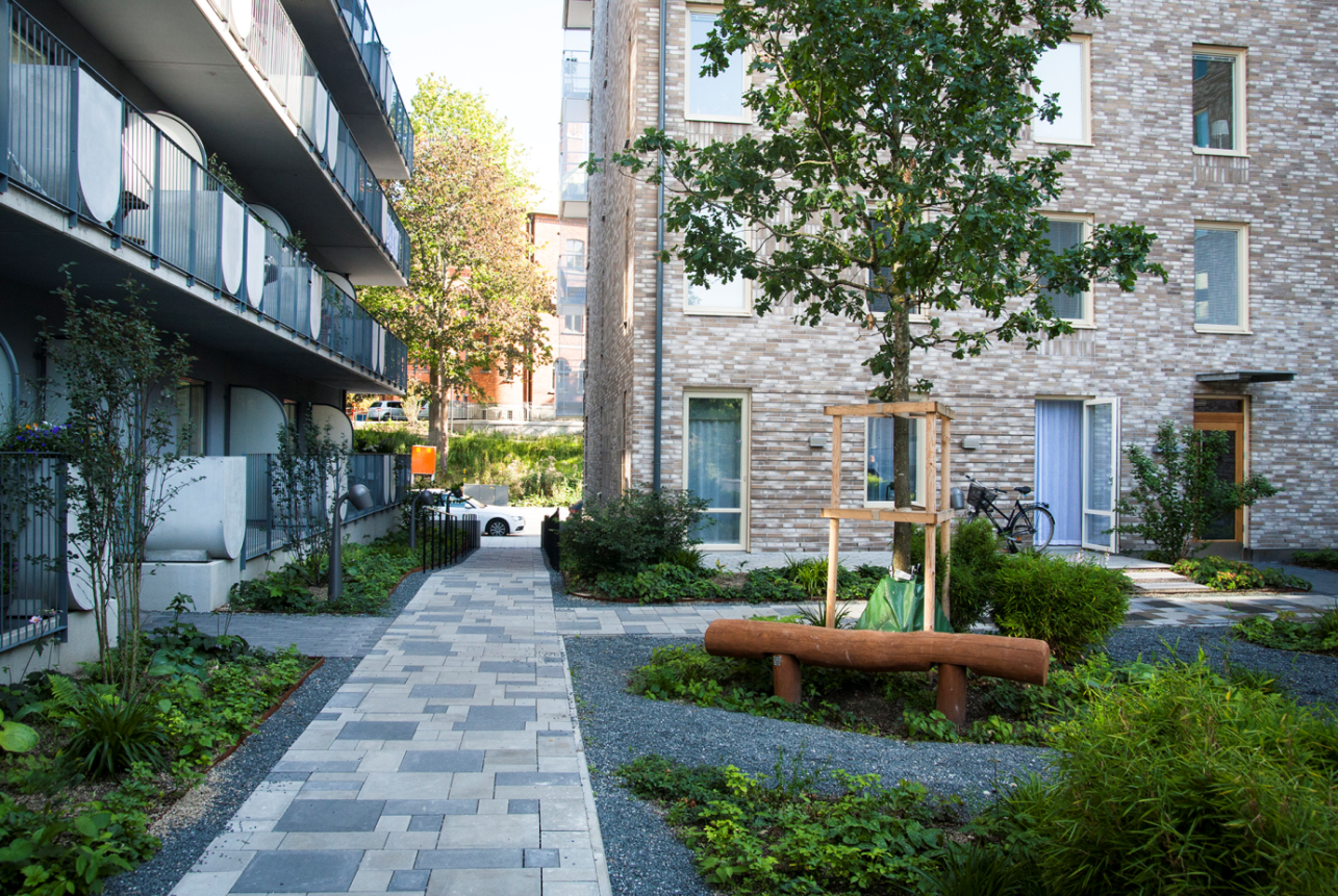 Kvarteret Stora Sjöfallet med naturinspirerad bostadsgård intill linjära och stiliserade gångar.