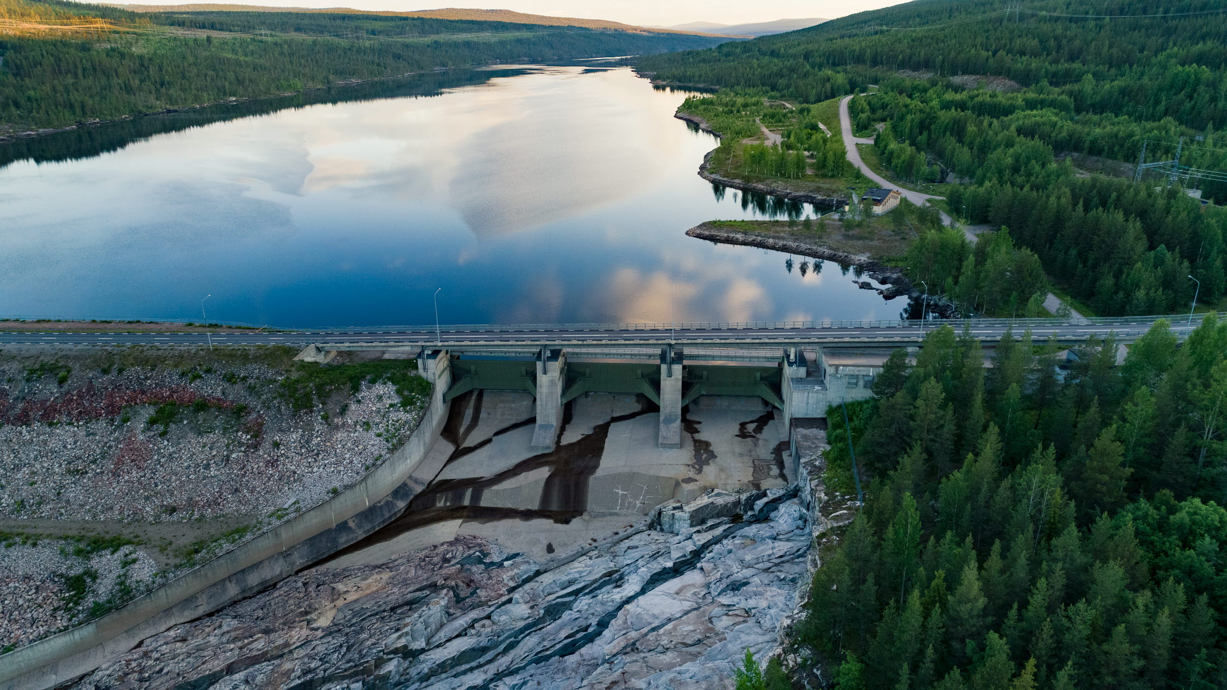 Dammanläggning i ett stort vattendrag med skog längsmed sidorna