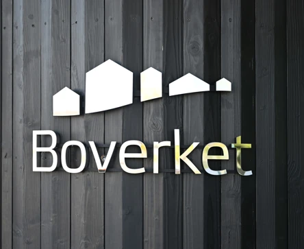 Boverkets logotyp på svart trävägg.