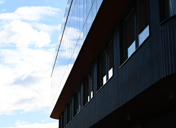 Svart fasad med stort glasparti.