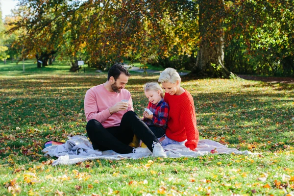 Familj som har picknick i en park.