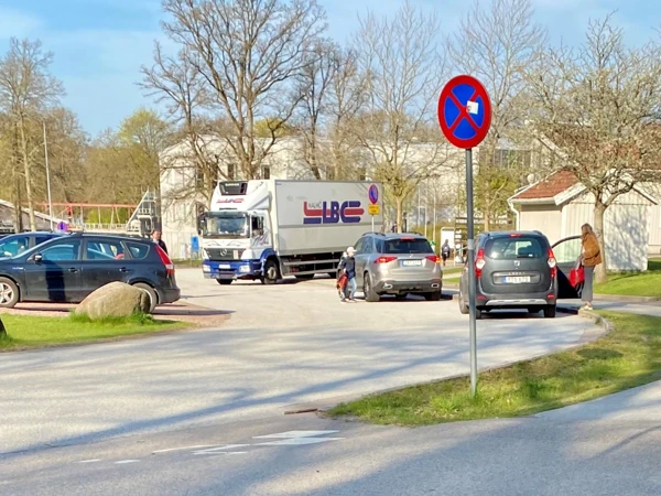Lastbil som kör vid en lämningsplats vid en skola.