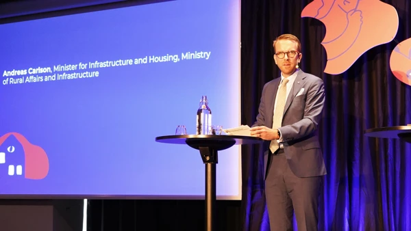 Foto av infrastruktur- och bostadsminister Andreas Carlsson på scenen.