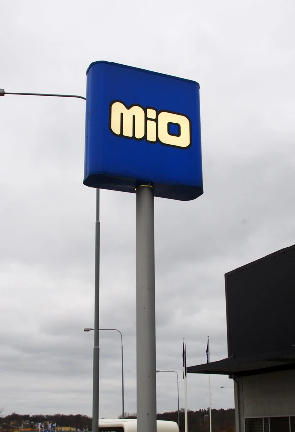 Foto av en hög blå skylt på stolpe med texten MIO utanför en möbelaffär..